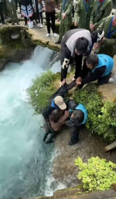 视频|大妈景区拍照跌入水中 安全人员抛救生圈救回