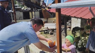 大火无情 灾民有爱．灾妇送视察群众冰条