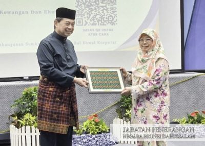 刘光明颁发纪念品 . 财经部52退休官员获表扬