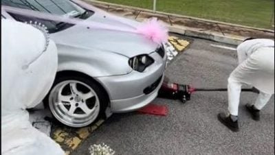 新娘车底盘太低卡路墩  新人大喜日蹲马路修车