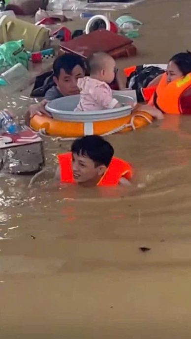 (图辑)水流湍急淹没屋顶 越南中部洪灾很严重